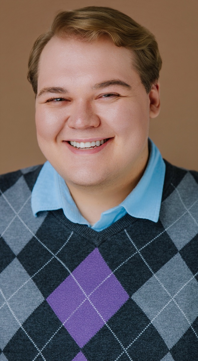 Ethan smiling in an argyle sweater
